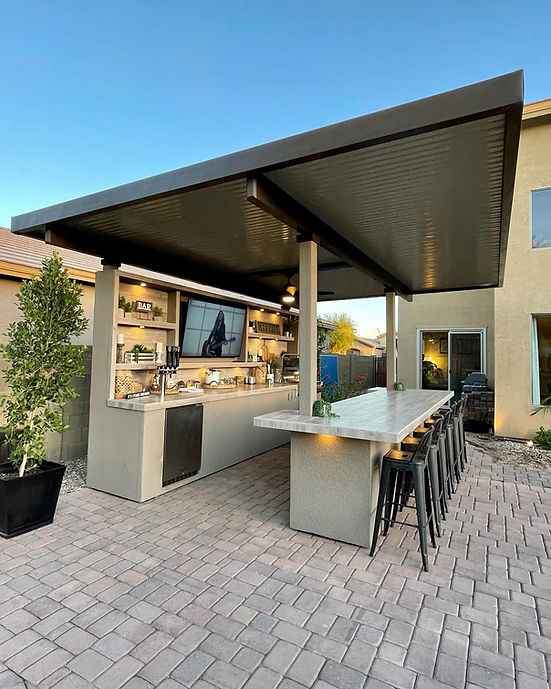 Modern outdoor kitchen with pergola and bar area on a clear day