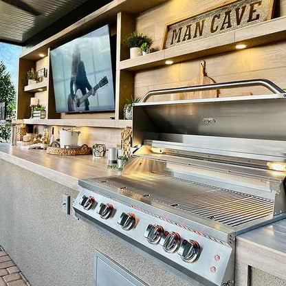 Outdoor kitchen with a large grill and 'Man Cave' sign.