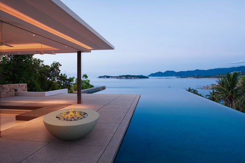 Outdoor infinity pool with fire pit and ocean view